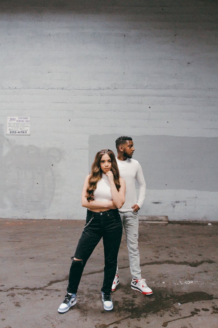 Home Fashionable duo posing in urban setting, showcasing modern streetwear style.